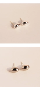 Macro detail of minimalist oval silver stud earrings with a high-polished mirror finish