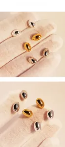 Detail presentation of oval bean stud earrings in polished gold and silver finishes