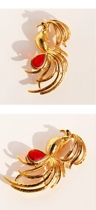 Detail of golden phoenix brooch with hollow feathers and a teardrop red gemstone