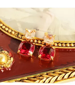 Vue détaillée de boucles d'oreilles rétro en laiton doré avec gemmes bordeaux et zircon