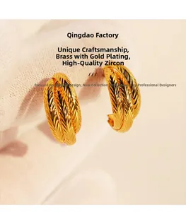 Macro detail of layered brass gold-plated C-hoop earrings with textured engraving