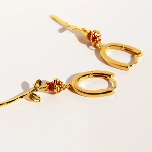 Elegant gold U-shaped hoop earrings with red enamel rose buds and detailed leaves
