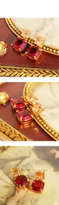 Gros plan de boucles d'oreilles vintage avec pierres rouge vin et zircon champagne doré