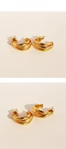 Detailed view of layered C-shape gold-plated brass earrings with textured faceted finish