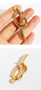 Macro detail of golden knotted ribbon brooch showing brushed metal texture and back pin clasp