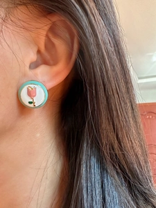 Detailed view of pink tulip enamel earring worn on ear showing fine craftsmanship