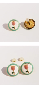 Close-up of pink enamel tulip earrings with mint green border and golden accents