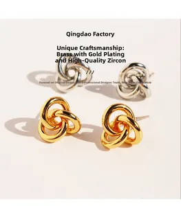 Detailansicht vergoldeter Messing-Ohrringe in verschlungener Ringform mit Zirkonia