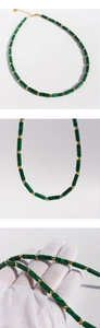 Détail de perles cylindriques en malachite verte avec entretoises dorées et fermoir
