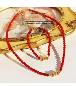 Vue détaillée de l'ensemble collier et bracelet en agate rouge avec nœuds dorés