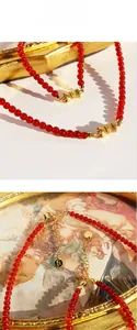 Détail de l'ensemble collier et bracelet en agate rouge avec des nœuds dorés
