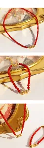 Gros plan de perles d'agate rouge et pendentif nœud doré avec détails en cristal