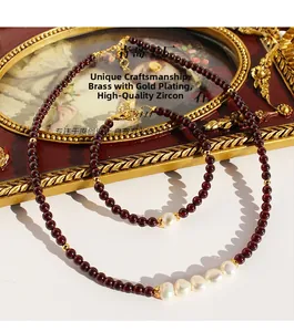 Détail de parure en grenat avec perles d'eau douce baroques et laiton plaqué or