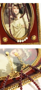 Détail du collier de grenat et perles avec fermoir mousqueton doré et chaîne d'extension