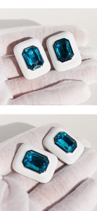 Detail of white enamel rectangular earrings with emerald cut blue crystal inlays