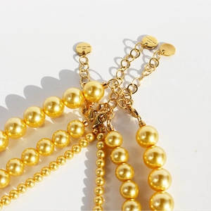 Elegant gold pearl necklaces and bracelets set with polished metal lobster clasp