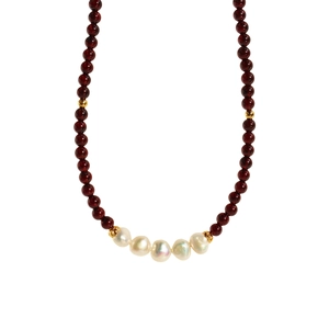 Collier artisanal en grenat avec perles baroques et dorées sur fond blanc