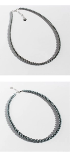 Detail van de donkergrijze parelketting met zilveren karabijnsluiting en verlenging