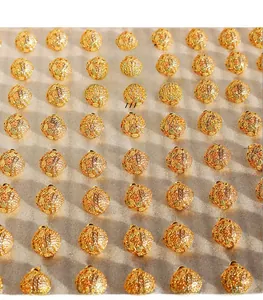 Detailed macro view of gold-plated brass flower earrings with premium zircon stones