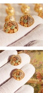 Detailed close-up of vintage gold floral earrings with colorful enamel roses and zircons