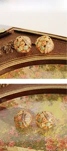 Macro shot of colorful enamel floral earrings with gold-plated hollow metal and zircons