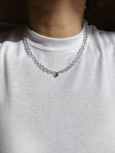 Dettaglio macro della collana di cristalli sfaccettati con pendente a sfera in argento