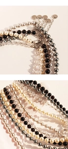 Dettaglio della collana di perle con cristalli sfaccettati e targhetta in argento lucido