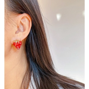 Sweet red strawberry enamel earrings with golden leaves and tiny rhinestones on ears