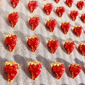 Artistic red enamel strawberry stud earrings with sparkling crystals and gold leaf detail
