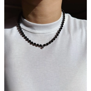 Collana minimalista di perline nere con un piccolo ciondolo a sfera d'argento da donna