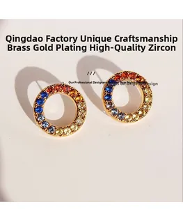 Macro view of gold-plated hoop earrings with multi-colored cubic zirconia inlays