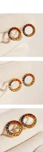 Macro detail of gold circle earrings with colorful rainbow gradient cubic zirconia