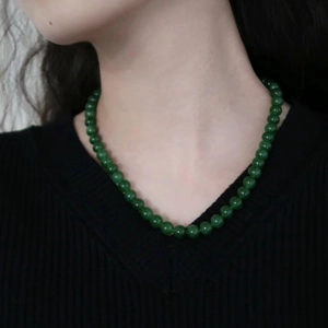 Elegant green agate bead necklace with a classic round bead design worn on collarbone