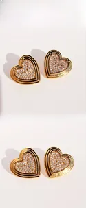 Macro detail of vintage heart stud earrings with pavé crystals and gold plated metal