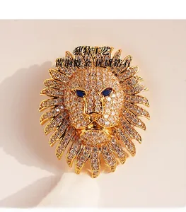 Détail macro d'une broche tête de lion en laiton plaqué or sertie de zircons