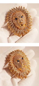 Vue détaillée de la broche tête de lion dorée de luxe avec zircons et yeux en pierre bleue