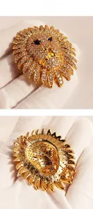 Vue détaillée d'une broche tête de lion avec cristaux pavés et yeux en pierres bleues