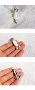 Detailed views of a silver candy brooch with white enamel and secure pin clasp mechanism