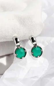 Dettaglio di orecchini d'argento con pietra verde rotonda e incastonatura a quattro griffe