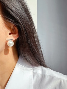 Minimalist pearl earrings with silver bar, close-up view of a model wearing the jewelry