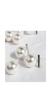 Macro view of high-lustre pearl earrings with sleek silver T-bar studs design