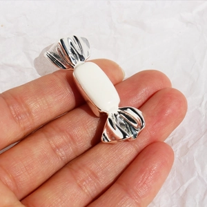 Silver candy brooch with white enamel detail and metallic crinkle texture
