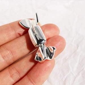 Polished silver candy-shaped brooch pin with handcrafted enamel and realistic metal folds