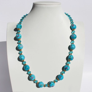 Collana artigianale di perle di vetro blu cielo con motivi floreali e cristalli su modello