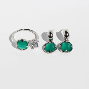 Set di gioielli in argento con pietre verdi e zirconi su uno sfondo bianco