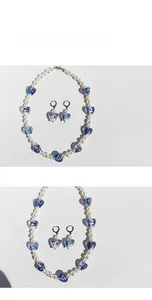 Detail view of pearl heart necklace and earrings set with blue floral ceramic patterns