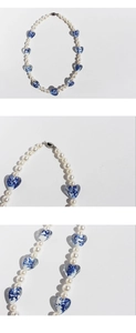 Macro detail of blue porcelain heart charm and white pearls on necklace set