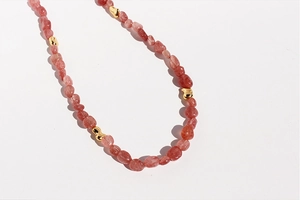Detalle de cuentas de cuarzo fresa rosa y detalles dorados en este collar fino