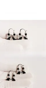 Vue détaillée des boucles d'oreilles en émail noir avec relief argenté texturé