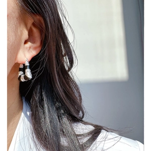 Boucles d'oreilles créoles en émail noir avec pavé de cristaux sur mannequin femme